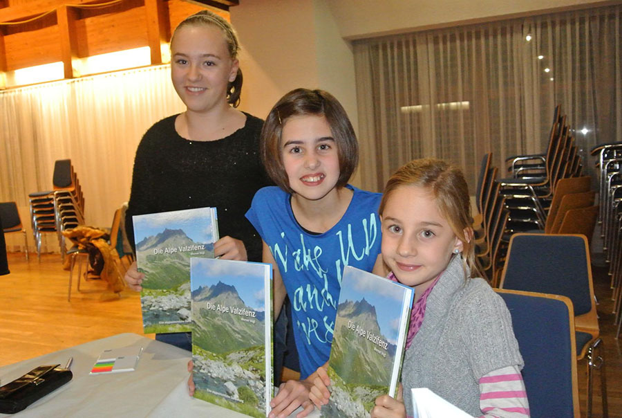 Kinder präsentieren das Buch über die Alpe